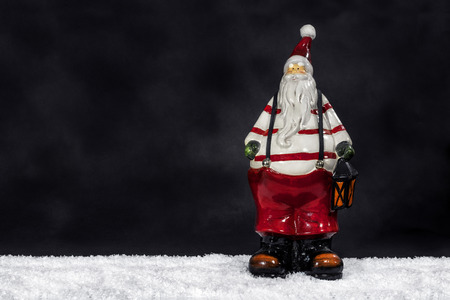 Merry Christmas - Big Santa Claus figure as funny festive Christmas decoration in red trousers, white shirt, bobble hat and white snow isolated on black dark background copyspace for text - festiveの写真素材