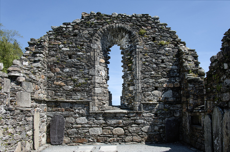 Ireland, Glendalough: Detail closeup of an old Irish chapel ruin with tombstones and clear blue sky in the background. June 10, 2015の写真素材