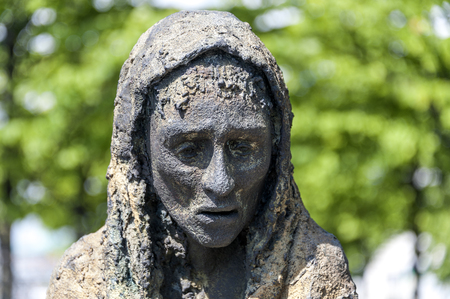 Ireland, Dublin: Famous Famine Memorial in the city center of the Irish capital - detail of woman's head with green trees in the background. June 09, 2015のeditorial素材