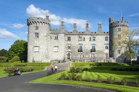 Ireland, Kilkenny: Park of the famous Castle of Butlers in the Irish town Kilkenny with green grass, bushes, people, tourists, residents and blue cloudy sky. June 10, 2015のeditorial素材