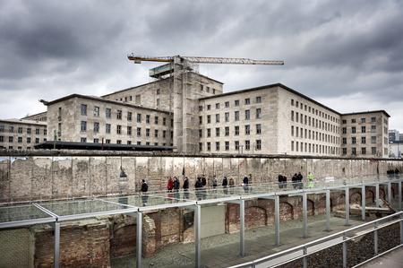 Germany, Berlin - February, 2017: A group of tourists in front of the documentation center Topography of Terror on a cloudy day with buildings Federal Ministry for Economic Affairs and Energy in the background.のeditorial素材