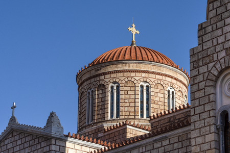 Dome of old byzantine greek orthodox church cathedral with red roof, golden Christian cross and blue sky in the background - concept religion god Christianity orthodox theology faith architectureの写真素材