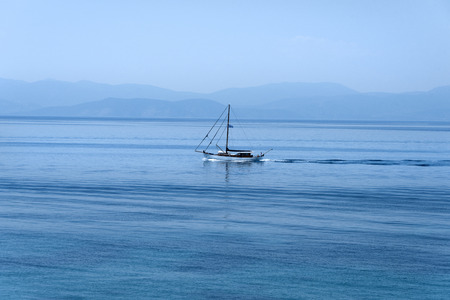Sailing boat, sea, calm water, ocean, waves, horizon, blue sky - concept travel nautics destination tourism holiday vacation luxury shipping ship navigation crossing seascapeの写真素材