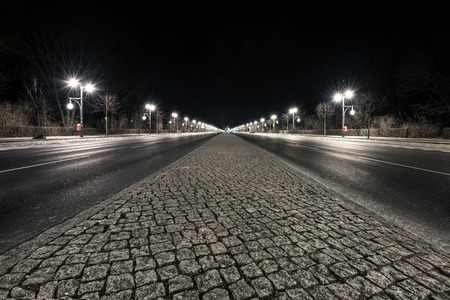 Germany, Berlin, Tiergarten, near Brandenburg Gate: Street scene with empty 17th of June Street (Strasse des 17. Juni) at night in the center of the German capital.の写真素材