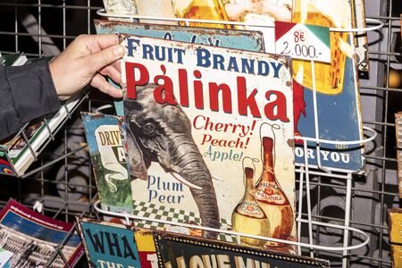 Hungary, Budapest, Great Market Hall: Hand holds an old retro colorful metal plate of traditional...