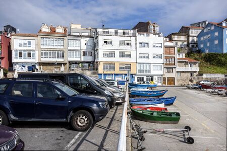 Spain, Finisterre: City center with harbor, colorful boats, houses, cars, blue sky. The town is located on a rock-bound peninsula and was famous for being the end of the known world. July 12, 2018のeditorial素材