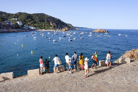 Spain, Catalonia, Costa Brava, Tossa de Mar: People tourists men women enjoy panorama view over beautiful bay with sailing ships, yachts, boats, blue mediterranean sea water, horizon. June 30, 2018のeditorial素材