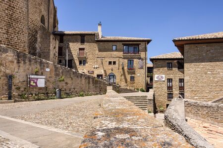Spain, Navarre, Ujue: View on central square of old small Spanish village next to famous church of Santa MarÃ­a de Ujue in the city center with blue sky - concept travel religion history. July 09, 2018のeditorial素材
