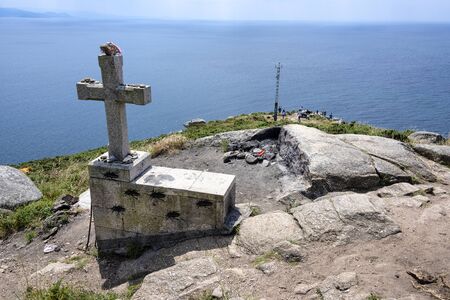 Spain, Finisterre: Pilgrim cross at the end of the famous Way of St. James with people and blue sky. It is located on rock-bound peninsula and was famous for being the end of the world. July 12, 2018のeditorial素材