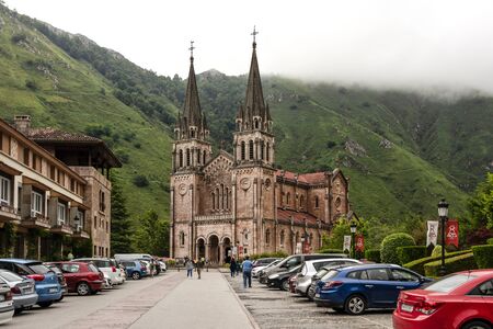 Spain, Asturias, Picos de Europa, Covadonga: Panorama view of famous Spanish Catholic church Basilica de Santa Maria la Real de Covadonga with people and green mountains in background. July 17, 2018のeditorial素材
