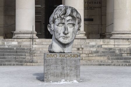 Germany, Bavaria, Munich, Koenigsplatz: Close up of sculpture head in front of famous Glyptothek museum at winter time with front facade columns in the city center of Bavarian capital. March 01, 2018のeditorial素材