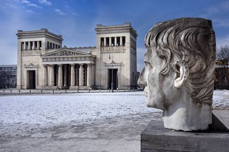 Germany, Bavaria, Munich, Koenigsplatz: Street scene with famous Propylaea city gate seen from Glyptothek at winter with snow and blue sky in the city center of the Bavarian capital. March 01, 2018のeditorial素材