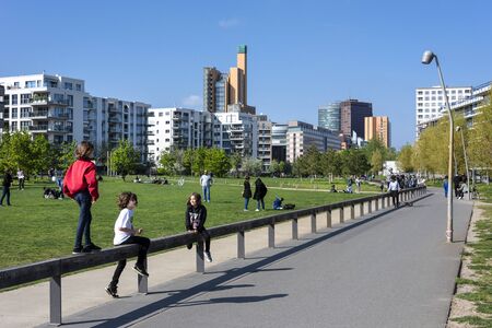 Germany, Berlin, Kreuzberg, Park am Gleisdreieck: Young people kids men women have fun in the city center of the German capital with famous Potsdamer Platz and blue sky in background. May 01, 2019のeditorial素材