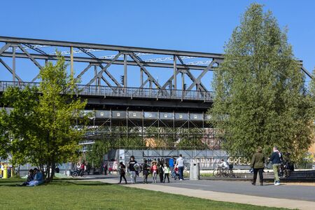 Germany, Berlin, Kreuzberg, Park am Gleisdreieck: Street scene with people, green trees, lwan, metro...