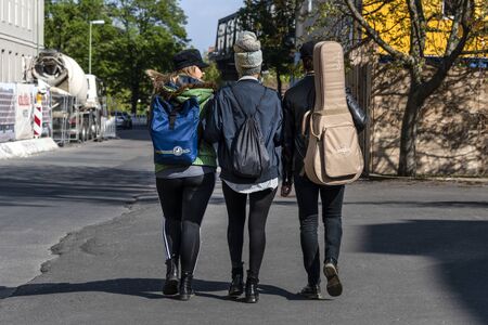 Germany, Berlin, Kreuzberg Schoneberg: Street scene with group of three young cool people from behind in the German capital - concept urban lifestyle coolness event music male female. May 01, 2019のeditorial素材