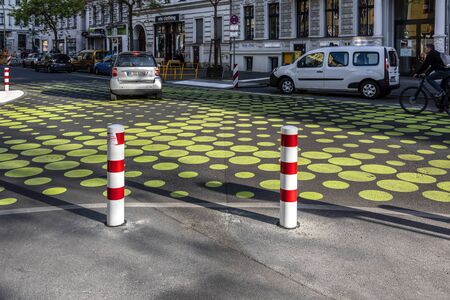 Germany, Berlin, Kreuzberg, Bergmannstrasse: Street scene with colorful painted crossroad, red white bollards, parking lots, typical house facades in the center of the German capital. May 01, 2019のeditorial素材