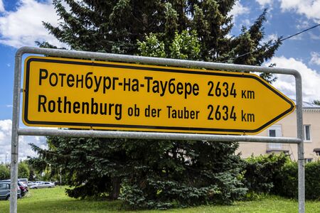 Russia, Vladimir Oblast, Golden Ring, Suzdal: Destination board to Rothenburg ob der Tauber, the twin city of the Russian town, in the city center with green tree and blue sky - travel friendshipの写真素材