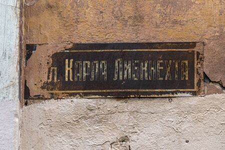 Russia, Artic, Barents Sea, Murmansk: Close up of barely legible street sign (Karl Liebknecht) in the city center of the famous northern Russian town on old broken house facade - remembrance travelの写真素材