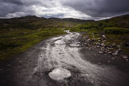 Russia, Arctic, Kola Peninsula, Barents Sea, Teriberka: Rural remote natural place with rocky wildness, dark grey gloomy cloudy sky and calm puddle water - concept outdoor adventure recreation natureの写真素材