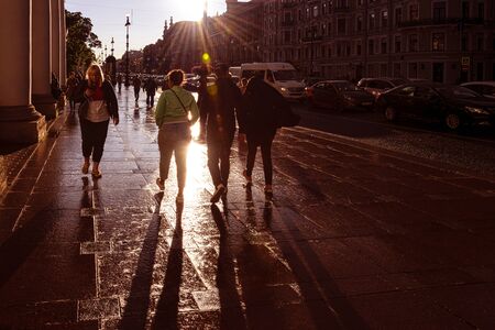 Russia, Saint Petersburg, near Neva river: Busy street scene with young people on famous Nevsky Prospect during summer rain against sunlight in the city center of the Russian town. Jul 08, 2019のeditorial素材