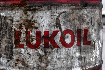 Russia, Arctic, Barents Sea, Murmansk: Old dented rusty oil drum of Lukoil company, one of the biggest oil and gas multinational energy corporations headquartered in Moscow - close up. Jul 14, 2019のeditorial素材