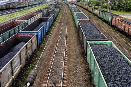 Russia, Barents Sea, Arctic, Murmansk: Long rows of train wagons with black coal, grey ash, tracks and skyline in the center of the Russian town - concept industry power energy supply transportationのeditorial素材