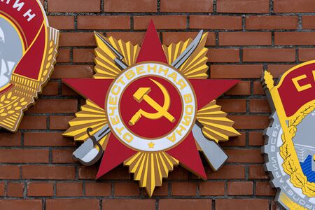 Russia, Arctic, Barents Sea, Murmansk: Colorful military order (Home Military) in star form on a brick exterior wall near famous Alyosha Monument of the northern Russian town - symbol. Jul 15, 2019のeditorial素材