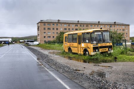 Russia, Arctic, Kola Peninsula, Barents Sea, Teriberka: Old broken kids school bus on green grass in the center of Lodeiny, the newer part of old Russian settlement small fishing village. Jul 17, 2019のeditorial素材