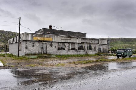 Russia, Arctic, Kola Peninsula, Barents Sea, Teriberka: Street scene with run down abandoned grocery...