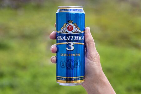 Russia, Saint Petersburg: Blue golden tin can of famous BALTIKA 3 beer in right hand, isolated. The Brewery is the second largest brewing company in Europe, leader of Russian beer market. Jul 18, 2019のeditorial素材