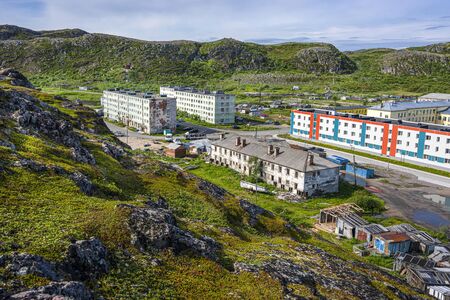 Russia, Arctic, Kola Peninsula, Barents Sea, Teriberka: Aerial view of Lodeiny, the newer part of old Russian settlement small fishing village with hills, run down apartment buildings. Jul 19, 2019のeditorial素材