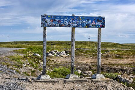 Russia, Arctic, Kola Peninsula, Barents Sea, Teriberka: Street scene with traffic sign to Teriberka, the old Russian settlement small fishing village with lots of stickers, landscape. Jul 19, 2019のeditorial素材