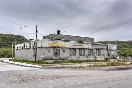 Russia, Arctic, Kola Peninsula, Barents Sea, Teriberka: Street scene with run down abandoned grocery store (Produktui) on a grey rainy day in the old Russian small fishing village. Jul 17, 2019のeditorial素材