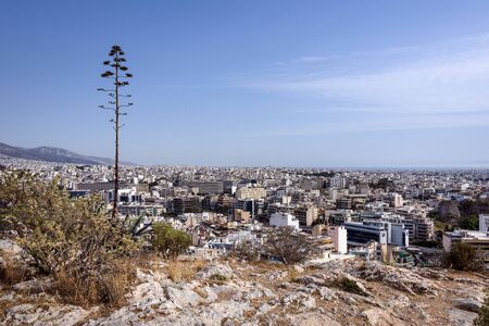 Greece, Athens: Panoramic view from famous Philopappu Hill over the city center of the Greek capital with roof tops, skyline, tree, houses, buildings and blue sky in the background. April 26, 2018のeditorial素材