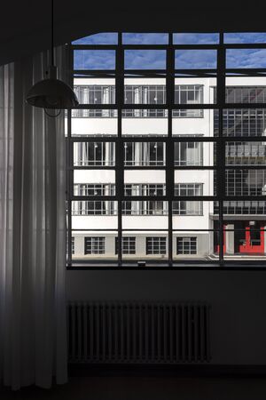 Germany, Saxony-Anhalt, Dessau-Rosslau: Bauhaus building seen from inside stairwell through famous glass windows construction with front facade - concept modern architecture art school. Dec 30, 2019のeditorial素材