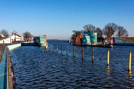 Germany, Greifswald, Wieck - December 30, 2016: Riverside with empty pier, houses and new barrage of the river Ryck in wintertime. The Barrage has been build between 2011 and 2016 by Ed. Zueblin AG.のeditorial素材