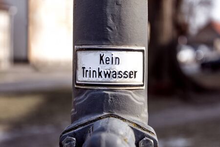 German metal sign on an old water pump: No drinking water (Kein Trinkwasser).の写真素材