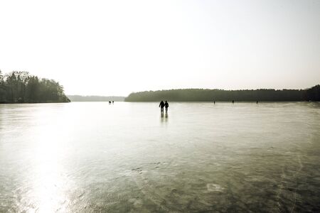 Panorama view of a frozen lake with people on the ice.の写真素材