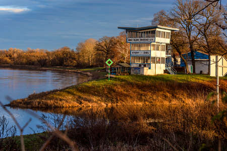 Germany, Saxony-Anhalt, Dessau-Rosslau: Mulde river with motor boat club house (MBC Elbe Dessau), calm floating water, trees near Leopoldshafen in the city of the famous German town. Dec 30, 2019のeditorial素材