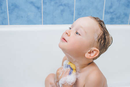 Boy washes in bathtub, baby washes with foam neck