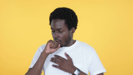 Sick Casual African Man Coughing Isolated on Yellow Backgroundの写真素材