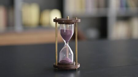 Close Up of Hourglass on Businessman Office Table
