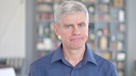 Portrait of Handsome Middle Aged Man saying No by Shaking Headの写真素材