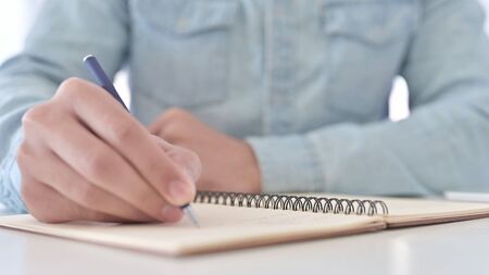 Close Up of Man Hands writing Notes on Dairyの写真素材