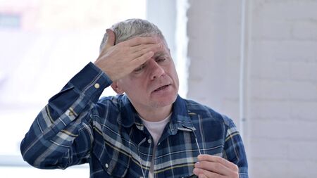 Portrait of Tired Casual Middle Aged Man having Headacheの写真素材