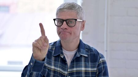 Portrait of Middle Aged Male Designer saying No by Finger Signの写真素材
