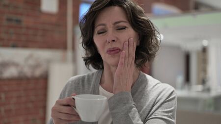 Portrait of Old Woman having Toothache by Drinking Coldの写真素材