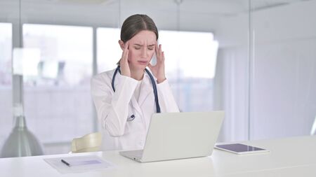Hardworking Young Female Doctor having Headacheの写真素材