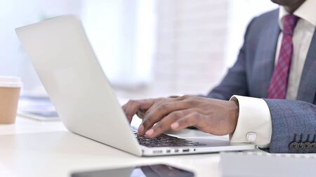 Close up of Hands of Professional African Man working on Laptop