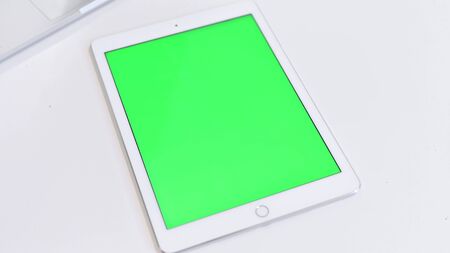 Top View of Tablet with Chroma Key Screen on White Tableの写真素材